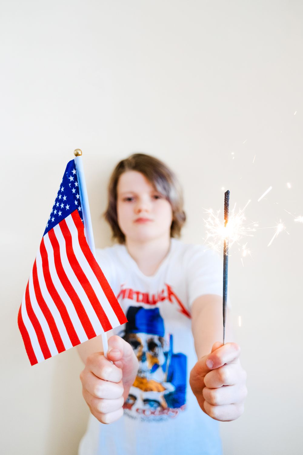 Kid holding an American flag and a sparkler