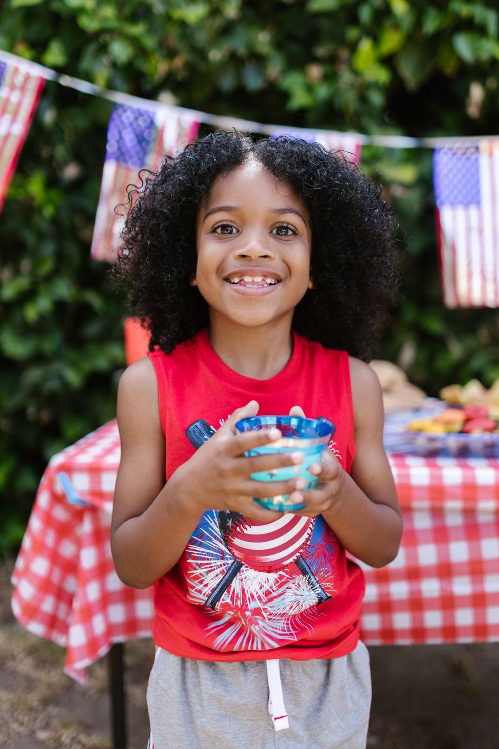 Smiling girl in a red top at a July 4th picnic