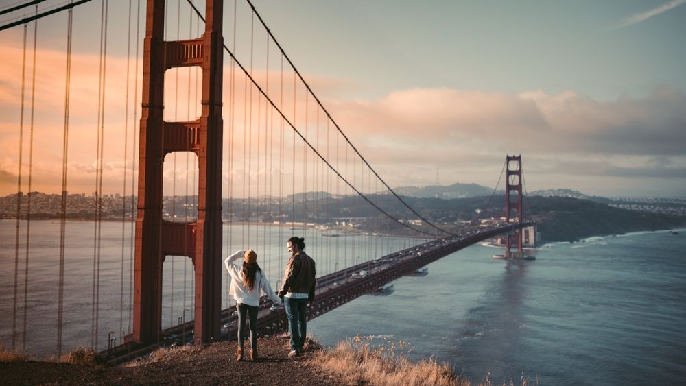 Couple looking at the Golden Gate Bridge at sunset