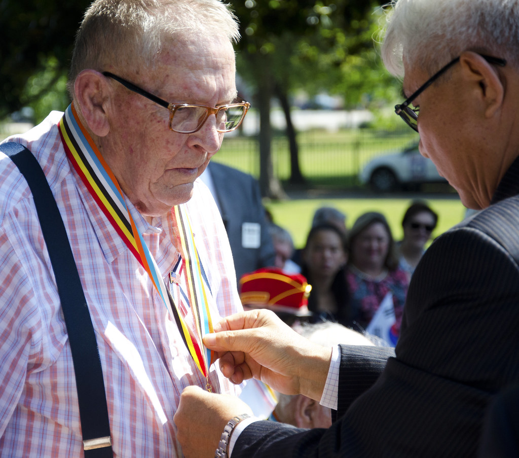 Two older veterans in conversation at a Korean War remembrance ceremony