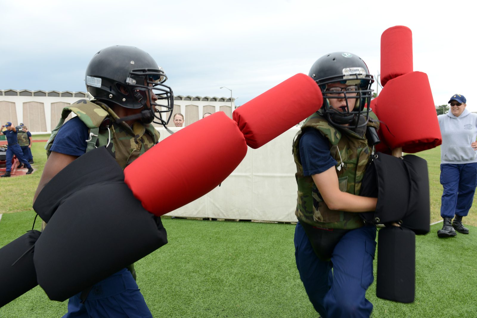 Coast Guard recruits train with pugil sticks on the field at Training Center Cape May