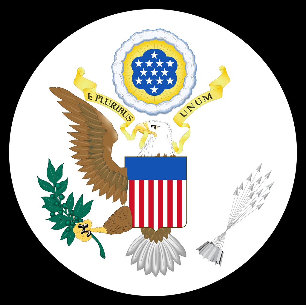 The obverse of the Great Seal of the United States, an eagle with shield, olive branch and arrows